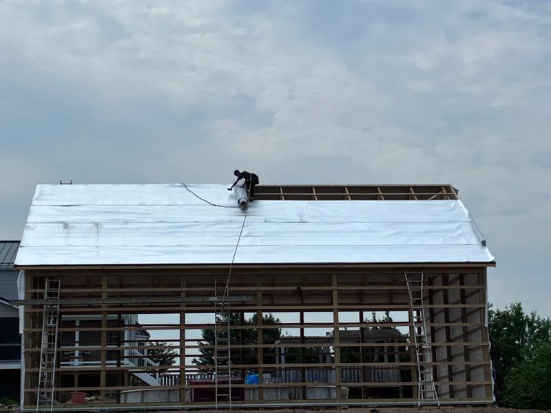 Roof underlayment being installed on a large building