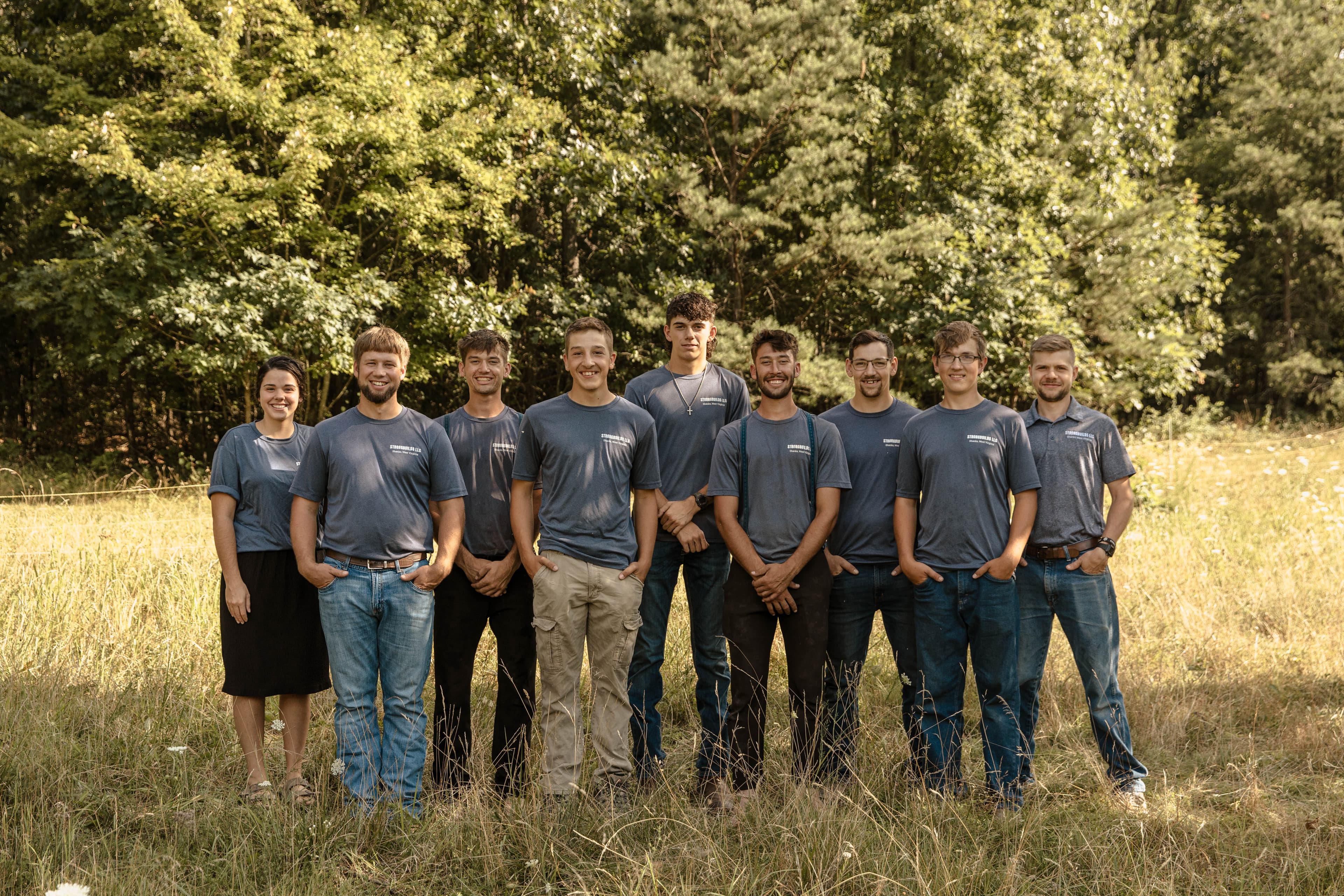The nine-person Strongbuilds LLC crew standing together outdoors